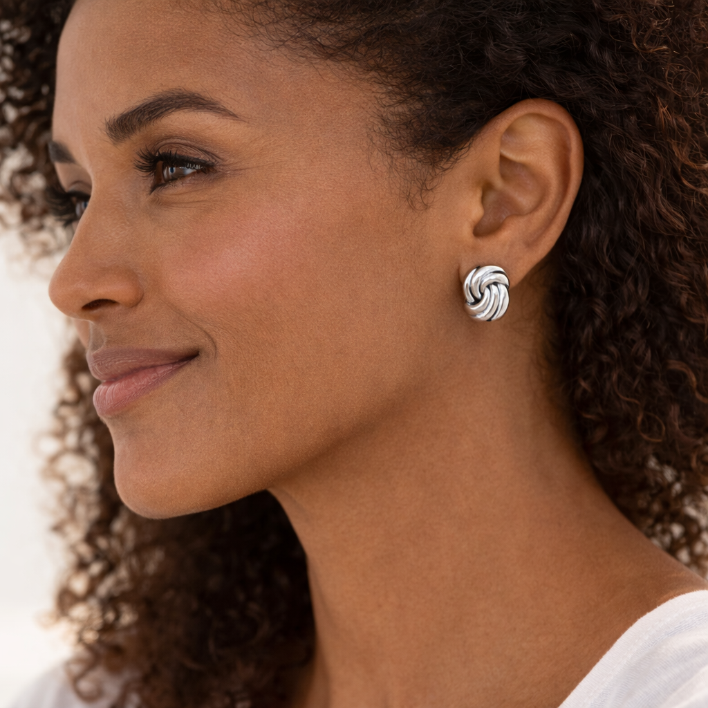 Close-up of a woman wearing a silver earring with a white background