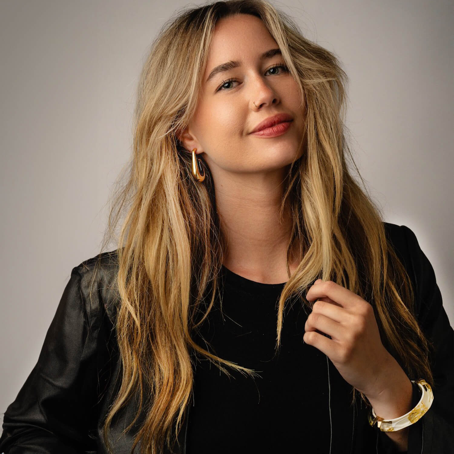 woman wearing gold earrings and leather jacket