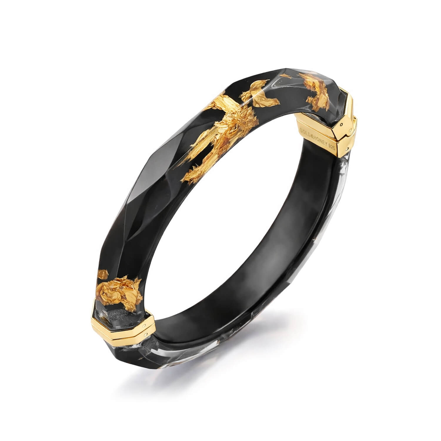 Black and gold ring with intricate design on a white background