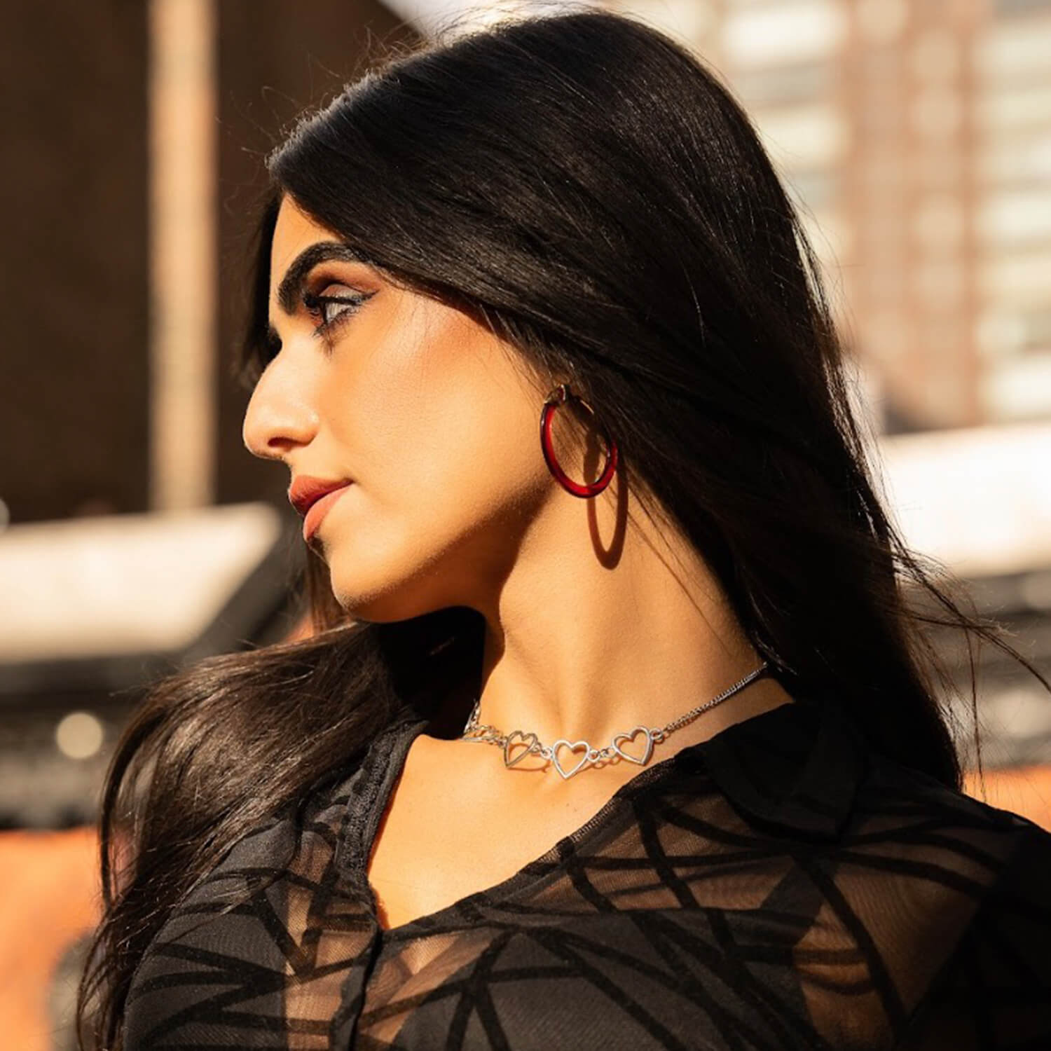 Woman wearing a black sheer top with a blurred background