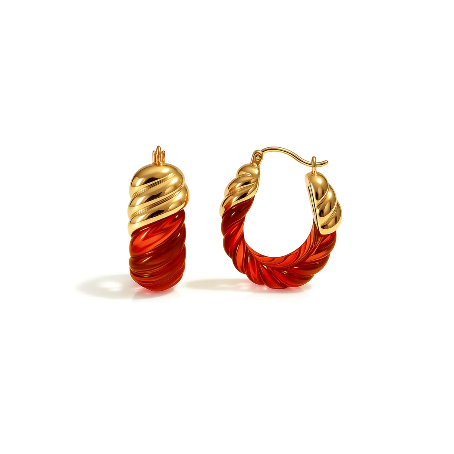 Gold and red hoop earrings on a white background