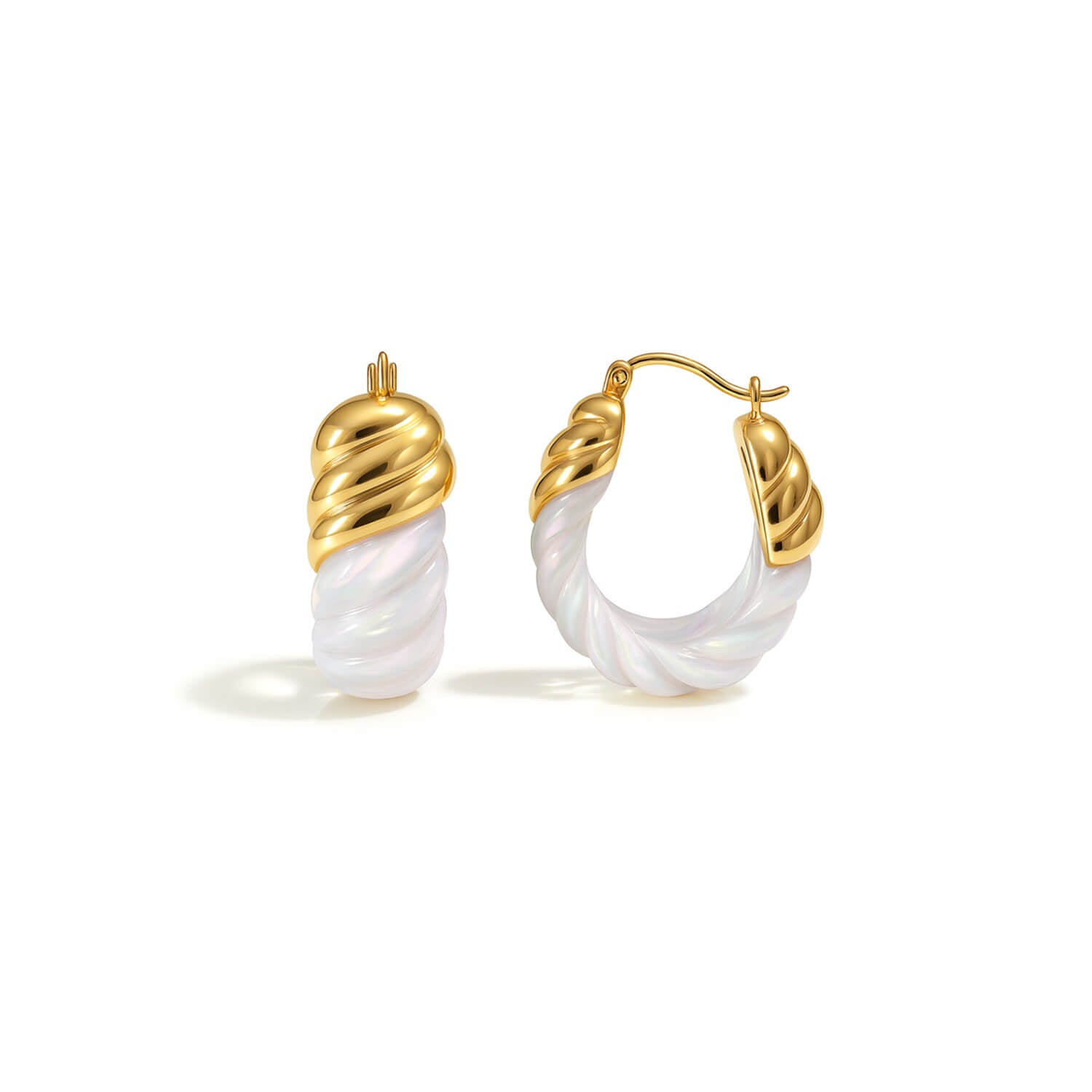 Gold and white hoop earrings on a white background