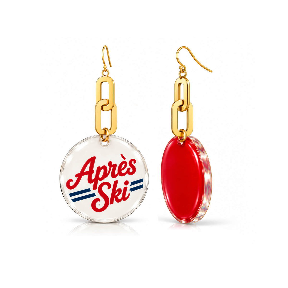 A pair of gold-tone dangle earrings on a white background. One earring has a round clear pendant with the words 'Après Ski' in red script and blue stripes.