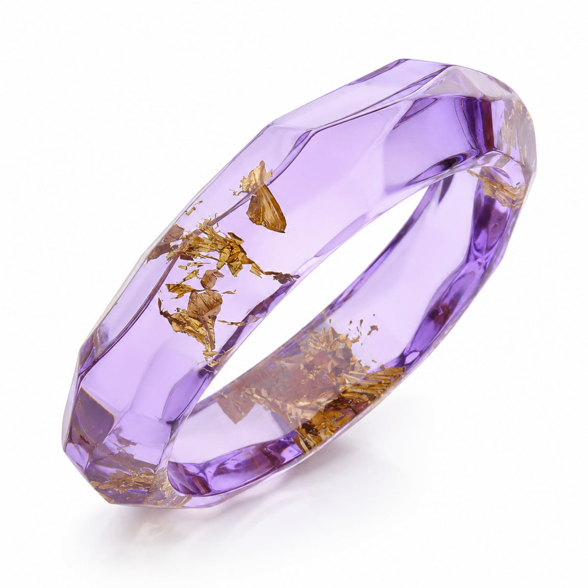 A faceted translucent lavender-purple ring with dried botanical elements and gold leaf inclusions, shown on a clean white background.