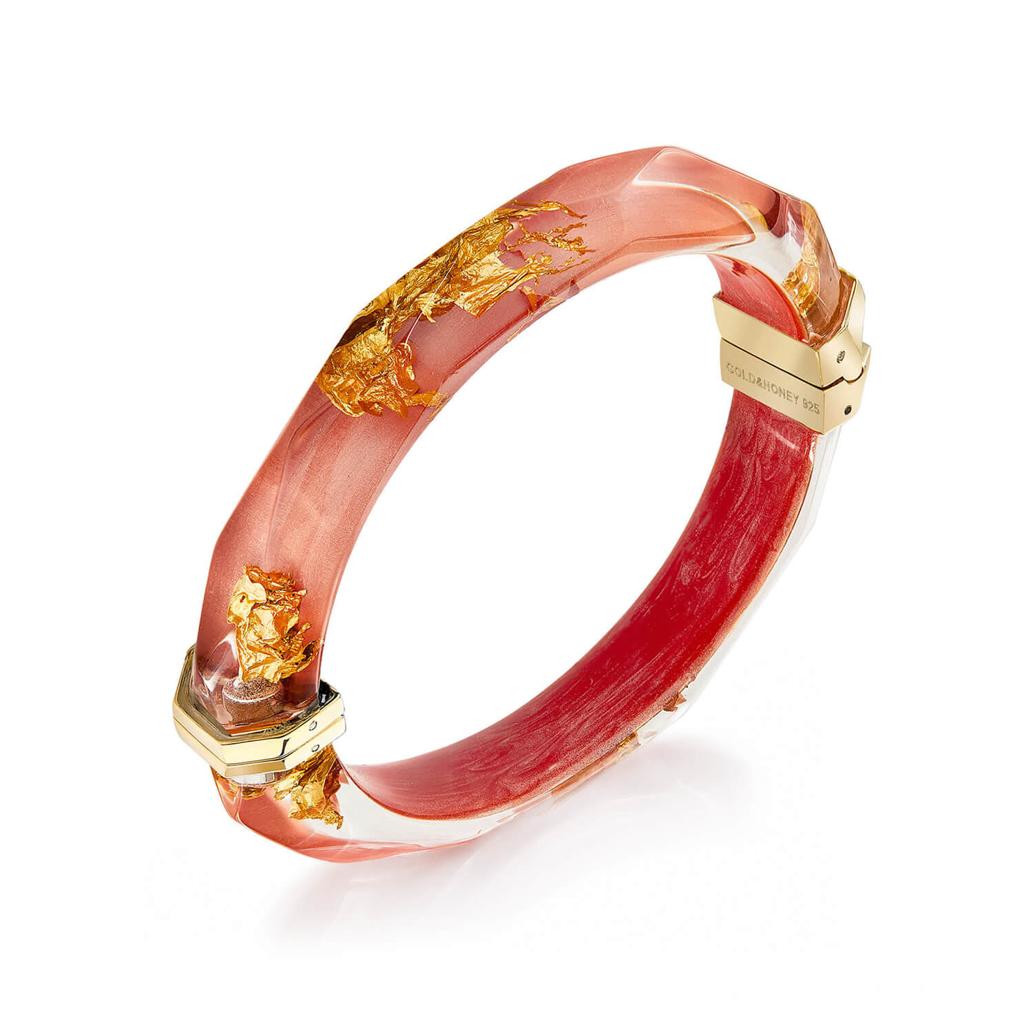 A gold-plated bangle bracelet with a translucent pinkish-red resin body containing gold leaf flakes, shown on a white background.