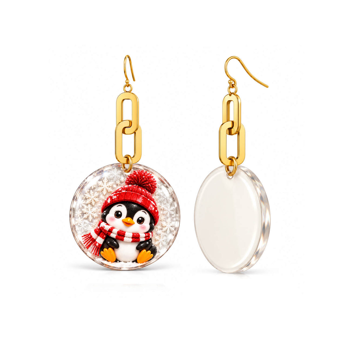 A pair of dangling earrings on a white background, showing both the front and back views. The front view features a round clear resin pendant with a penguin wearing a red knit hat and scarf, suspended from a gold link.