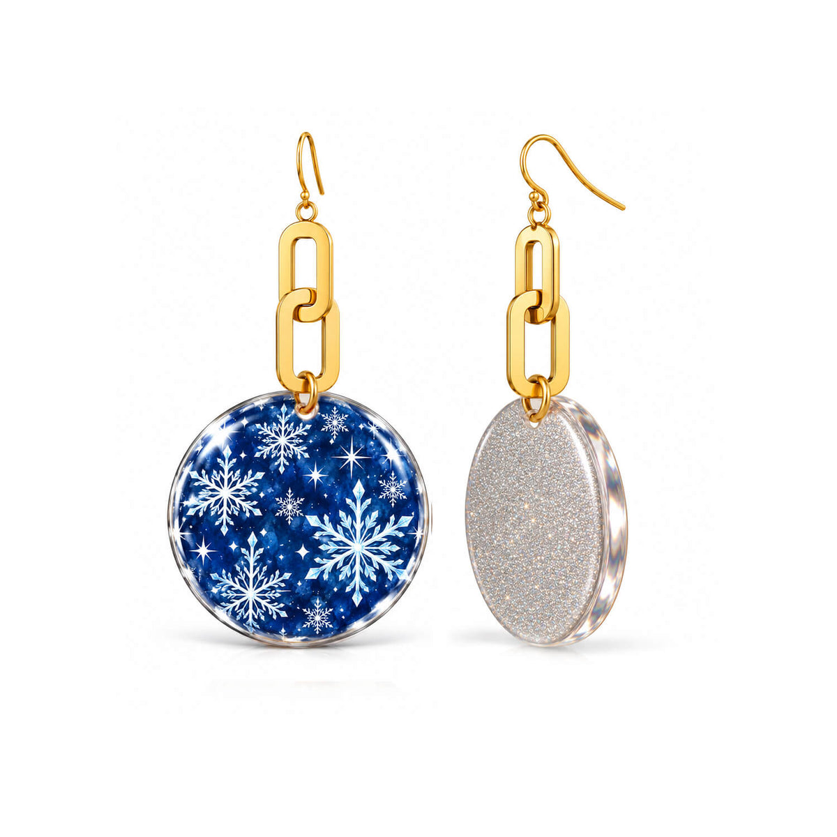 A pair of gold-tone dangle earrings with round disc charms. One charm is blue with a white snowflake pattern, and the other is textured silver glitter, both suspended from gold chain links on fishhook wires, shown against a plain white background.