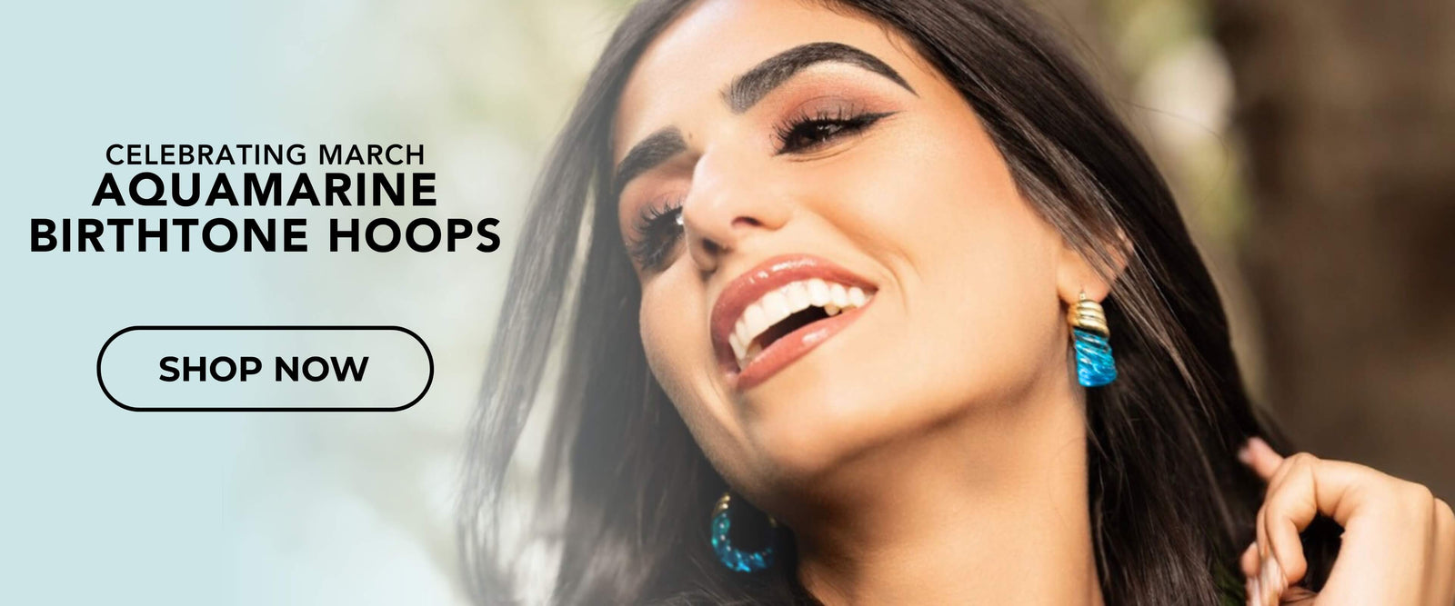 Woman wearing blue earrings with text celebrating March Aquamarine Birthstone Hoops and a 'Shop Now' button.