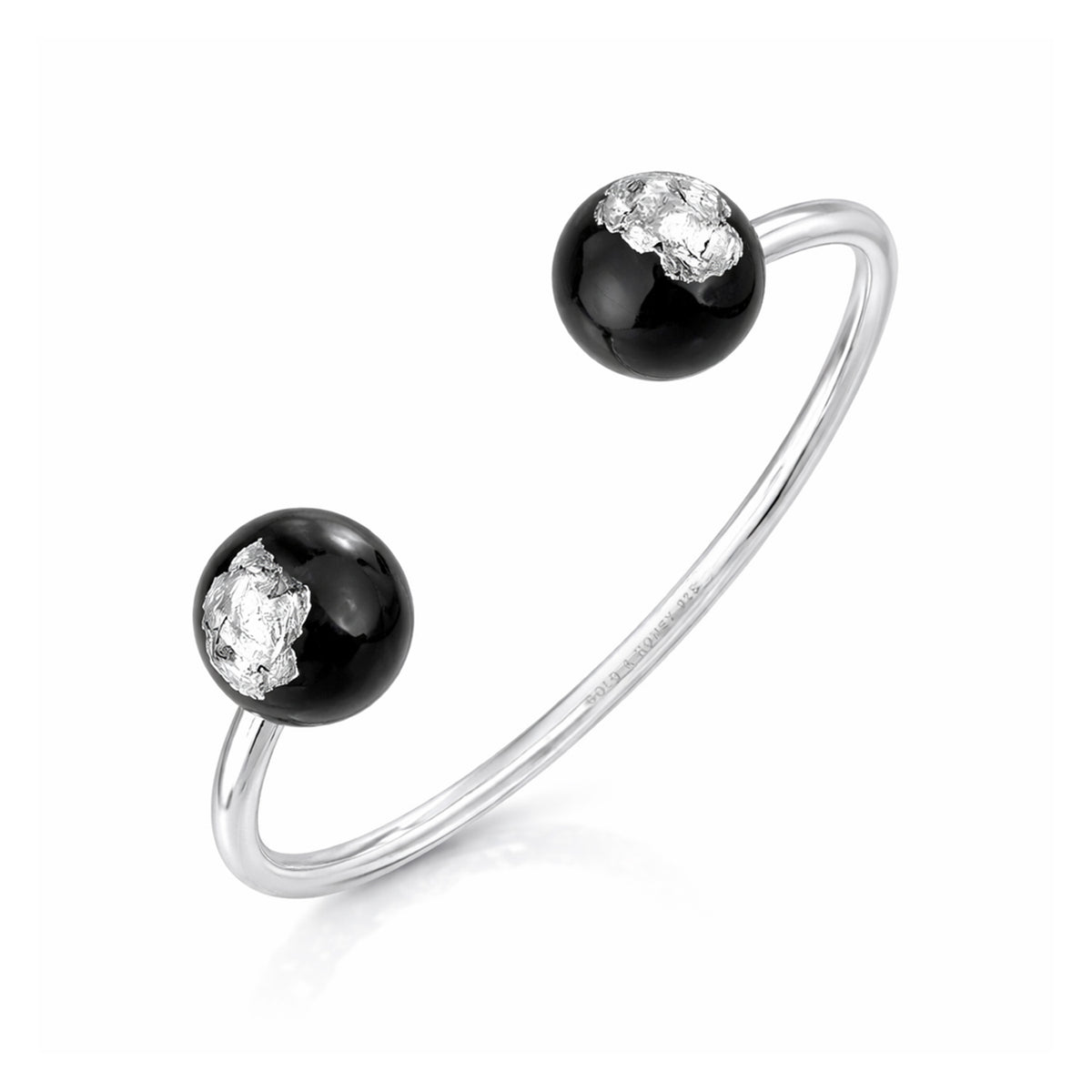 Silver bracelet with black beads and clear gemstones on a white background