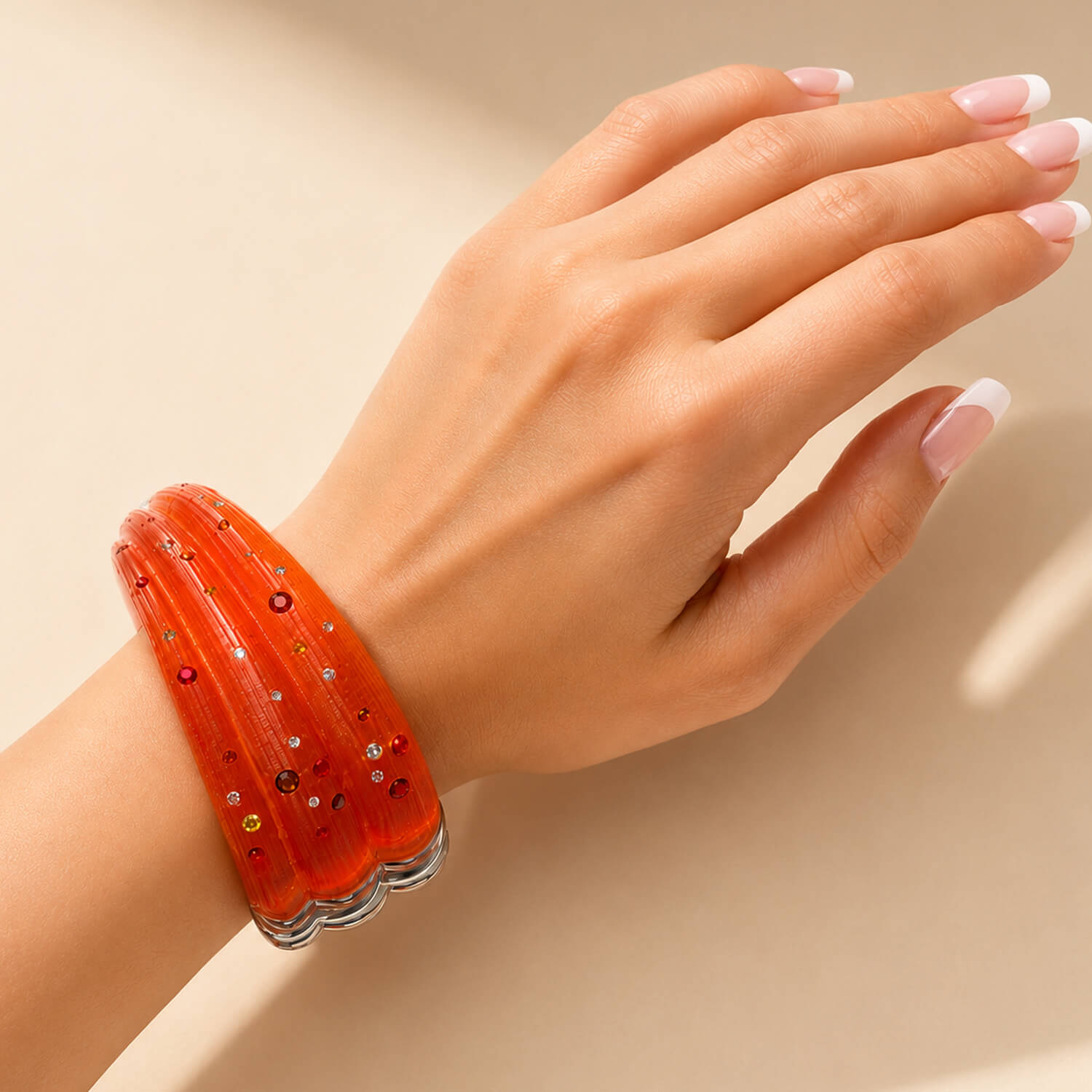 Hand wearing a red bracelet on a beige background