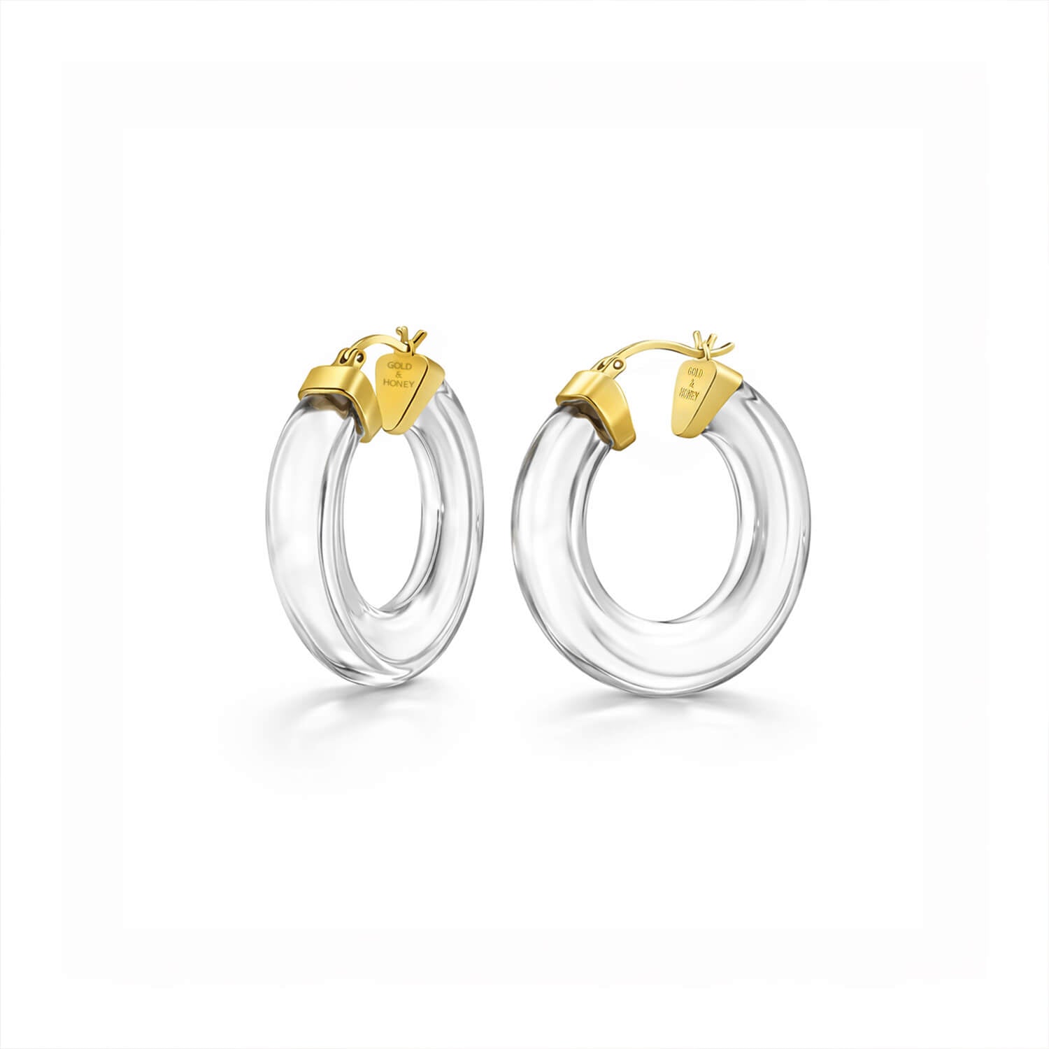 Clear hoop earrings with gold tops on a white background