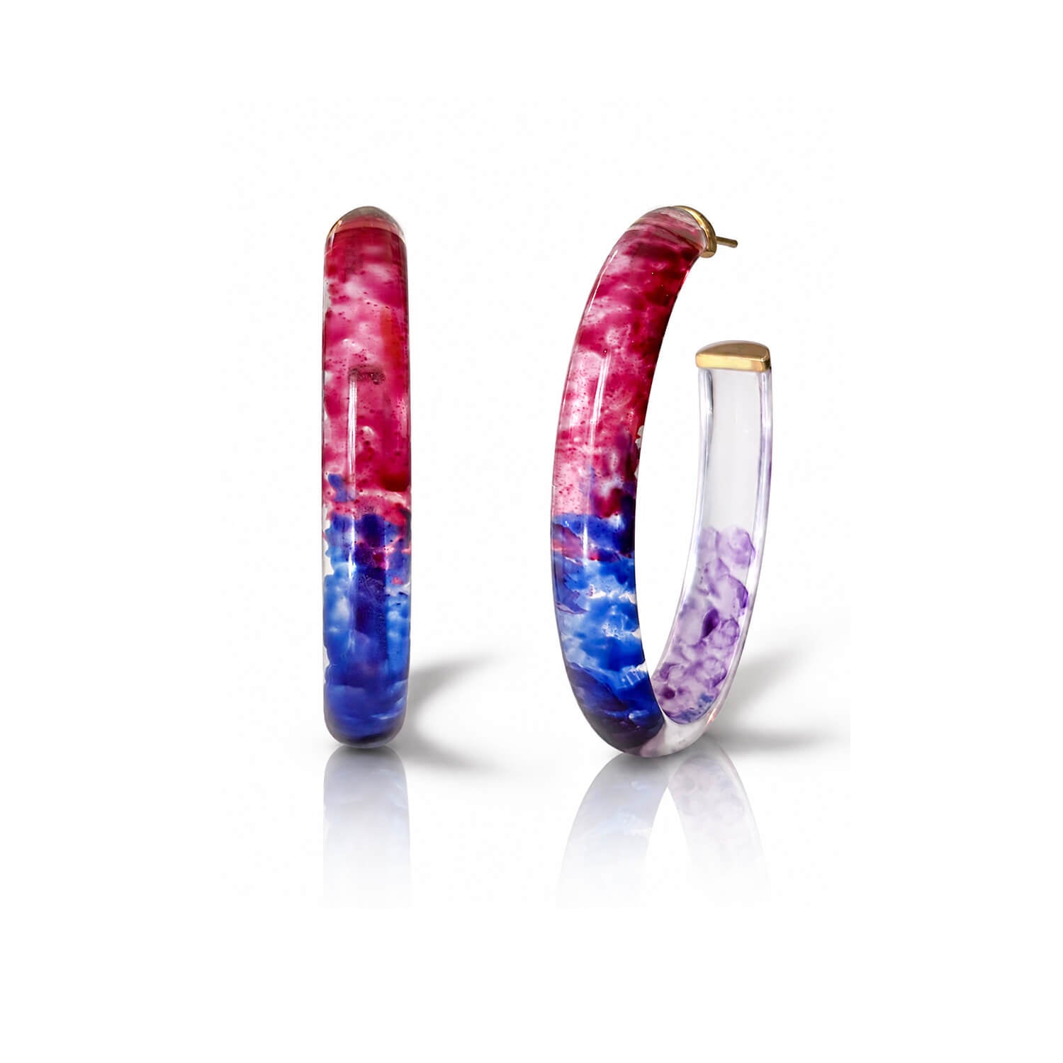 A pair of hoop earrings with a marbled, tie-dye pattern in pink, red, blue, and purple, accented with gold-tone metal caps on a white background.
