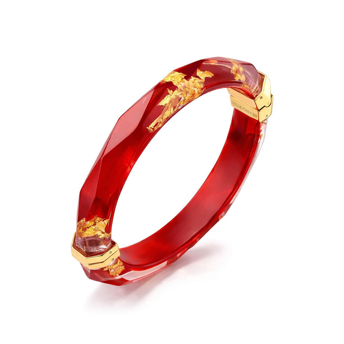 Red bracelet with gold accents on a white background