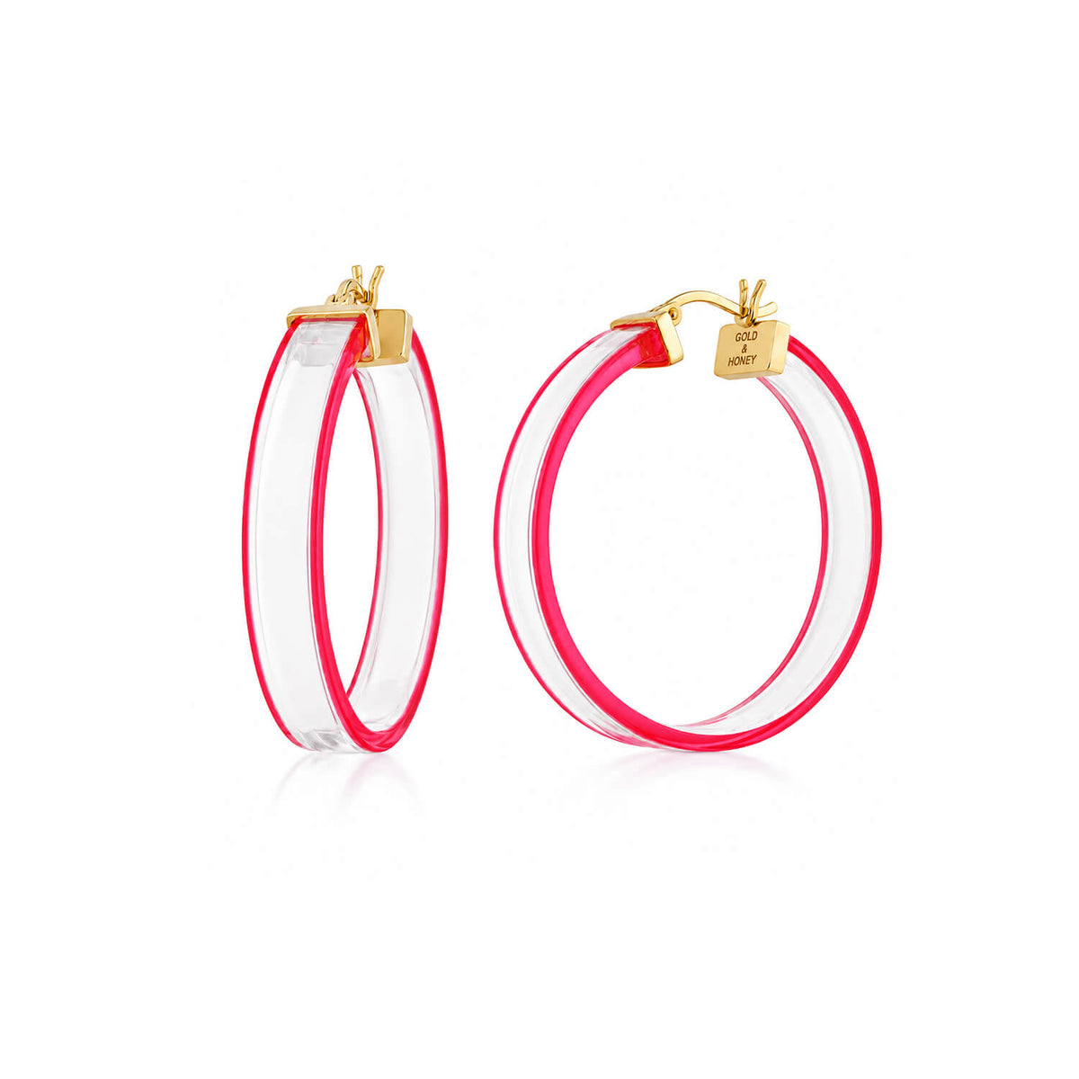 A pair of gold hoop earrings with a clear outer layer and a vibrant hot pink inner lining, shown on a clean white background.