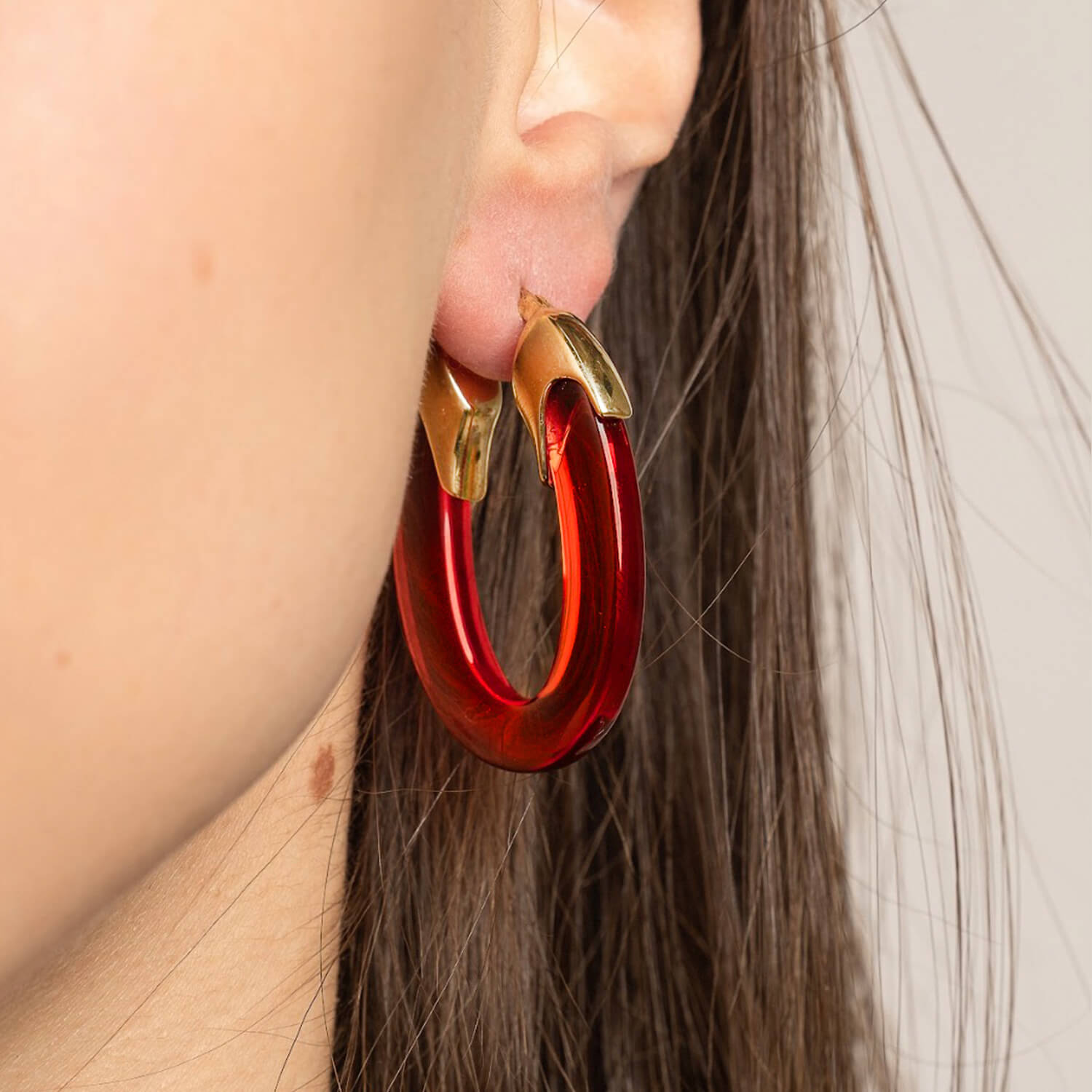 Purple hoop earrings with gold accents on a white background