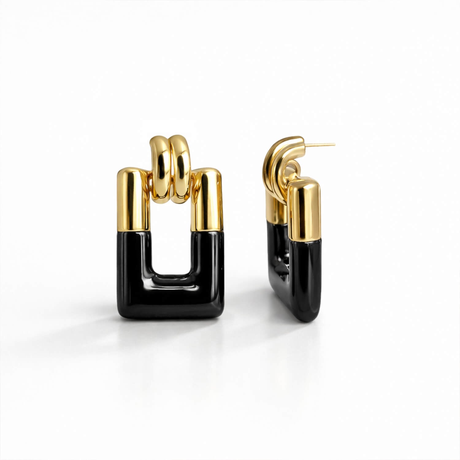 Gold and black hoop earrings on a white background