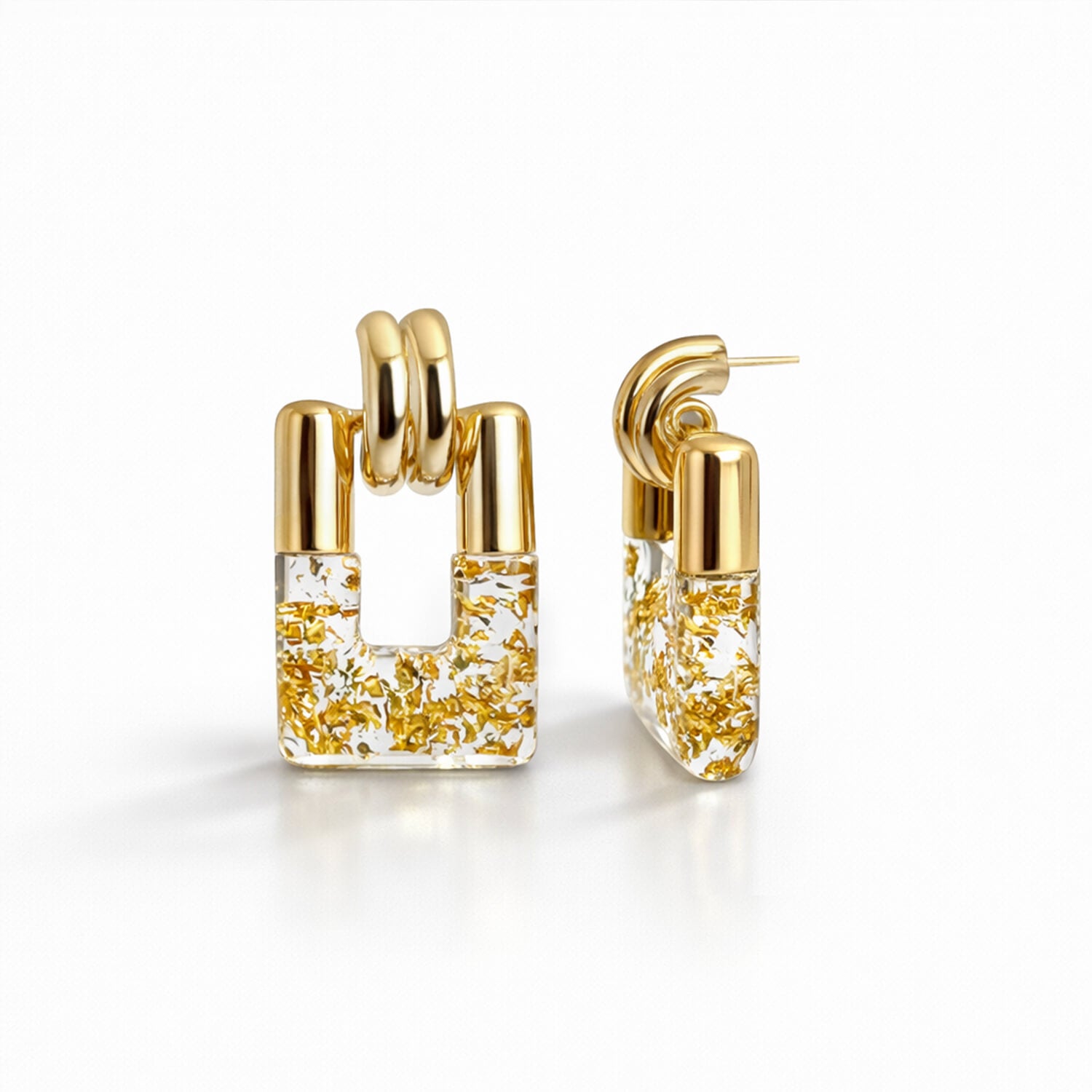 Gold hoop earrings with gold flakes on a white background