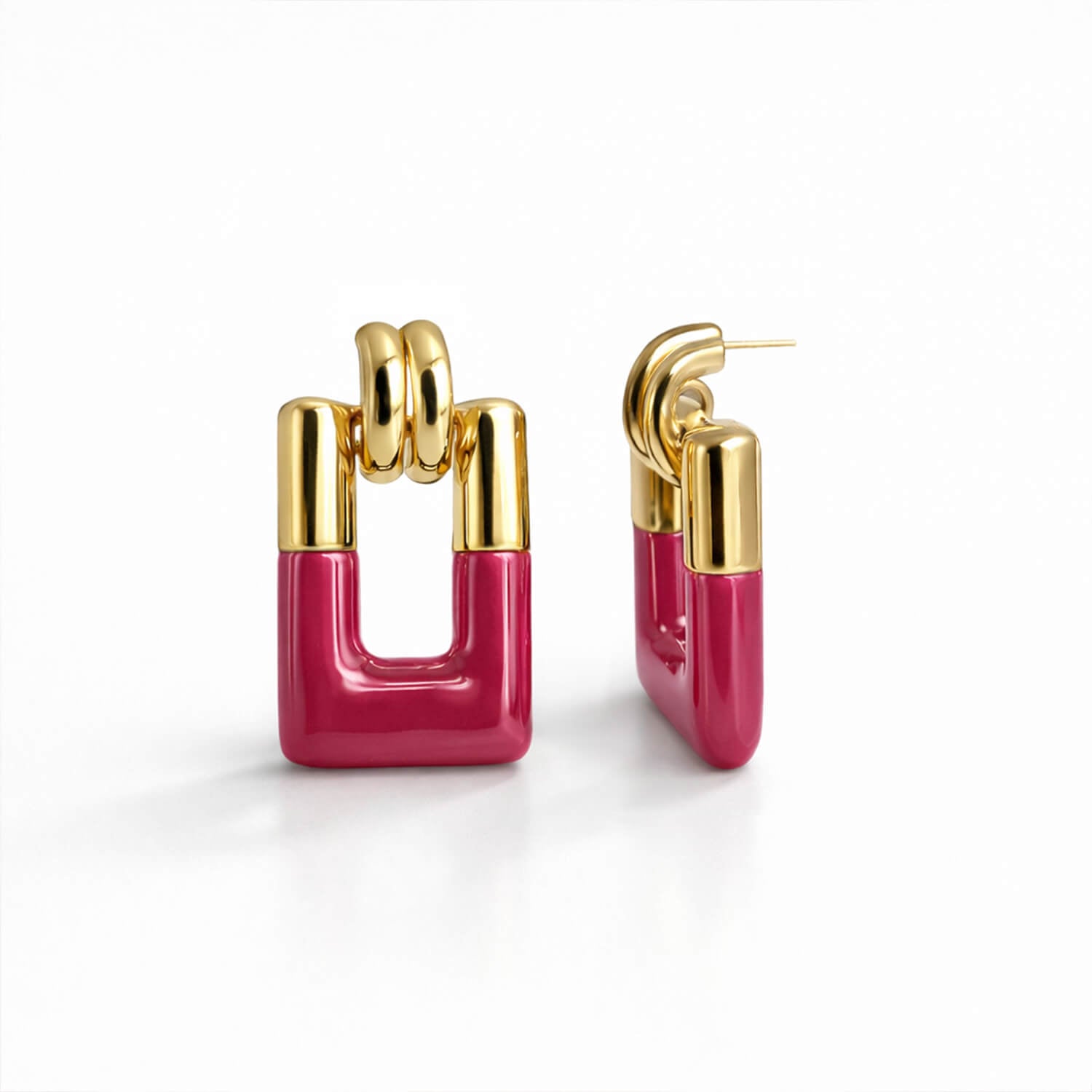 Gold and pink earrings on a white background