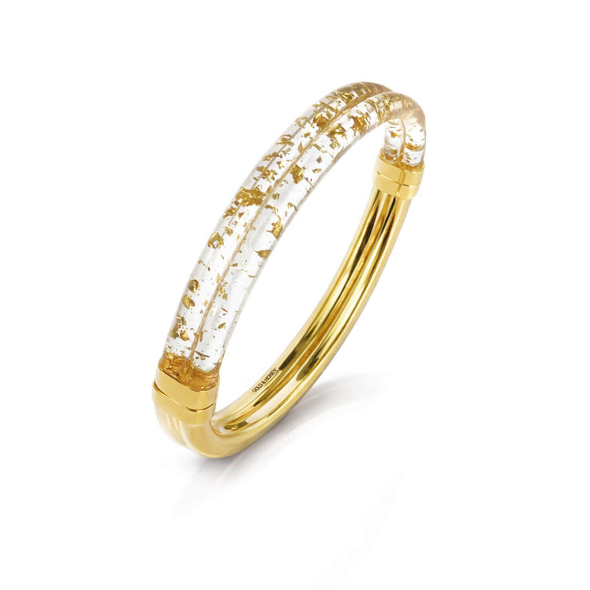 Gold ring with embedded clear material and gold flakes on a white background