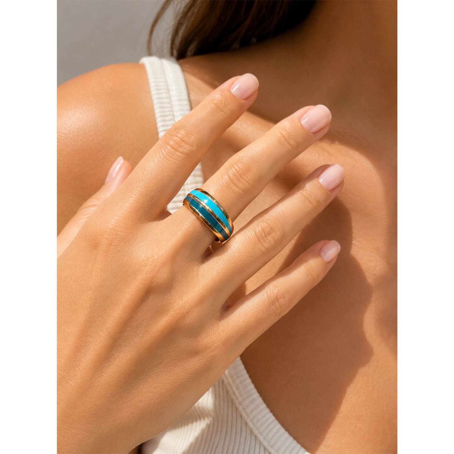 model wearing blue and gold enamel ring